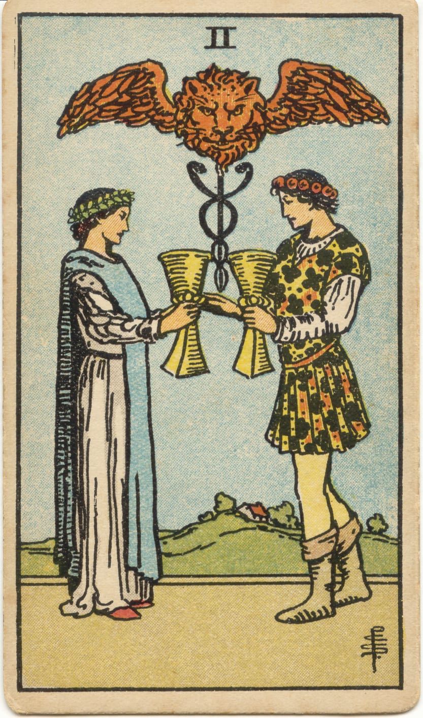 Карта Таро Двойка Кубков, 1909 год: юноша и девушка сближают золотые кубки под кадуцеем с крылатой львиной головой